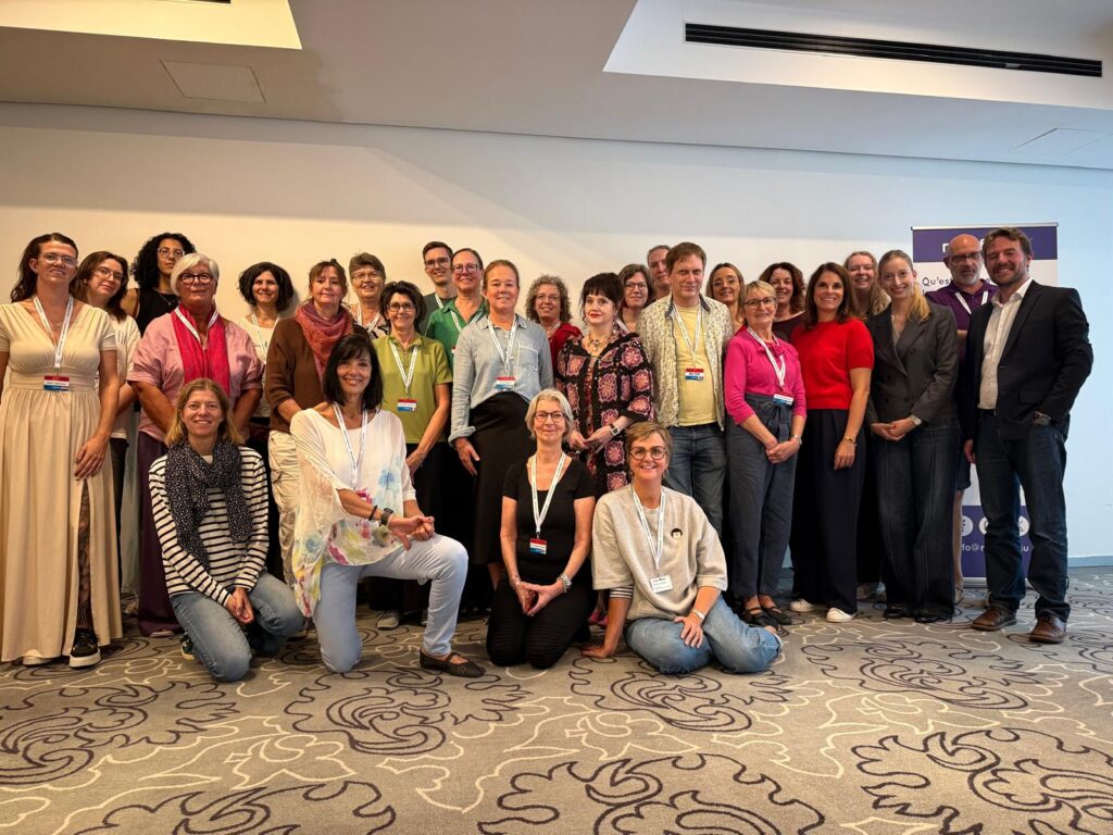 Many people standing in a room, posing for a group photo